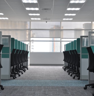 empty black rolling chairs at cubicles