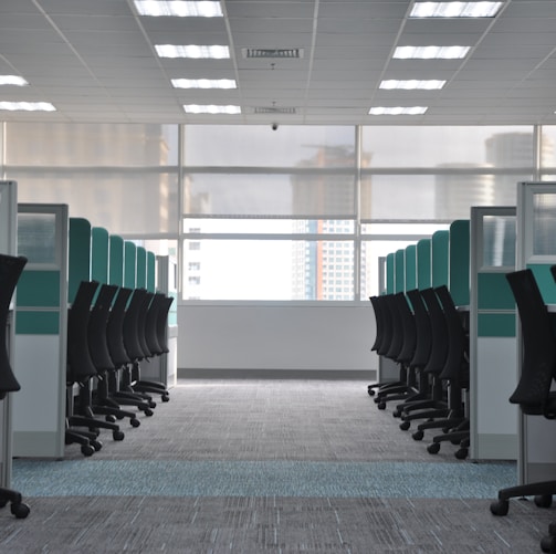 empty black rolling chairs at cubicles