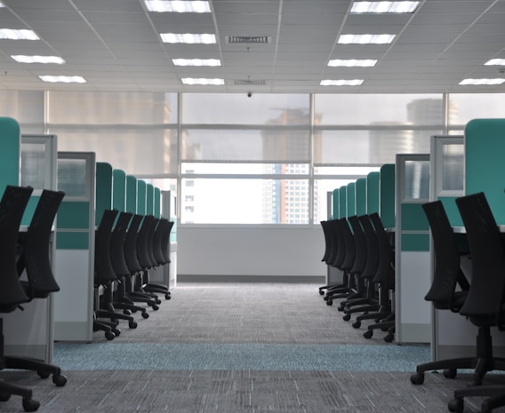 empty black rolling chairs at cubicles