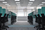 empty black rolling chairs at cubicles
