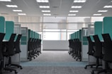 empty black rolling chairs at cubicles
