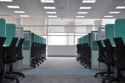 empty black rolling chairs at cubicles