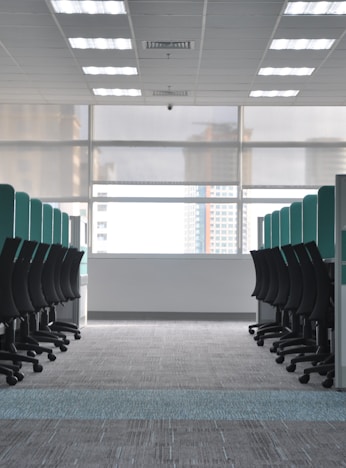 empty black rolling chairs at cubicles