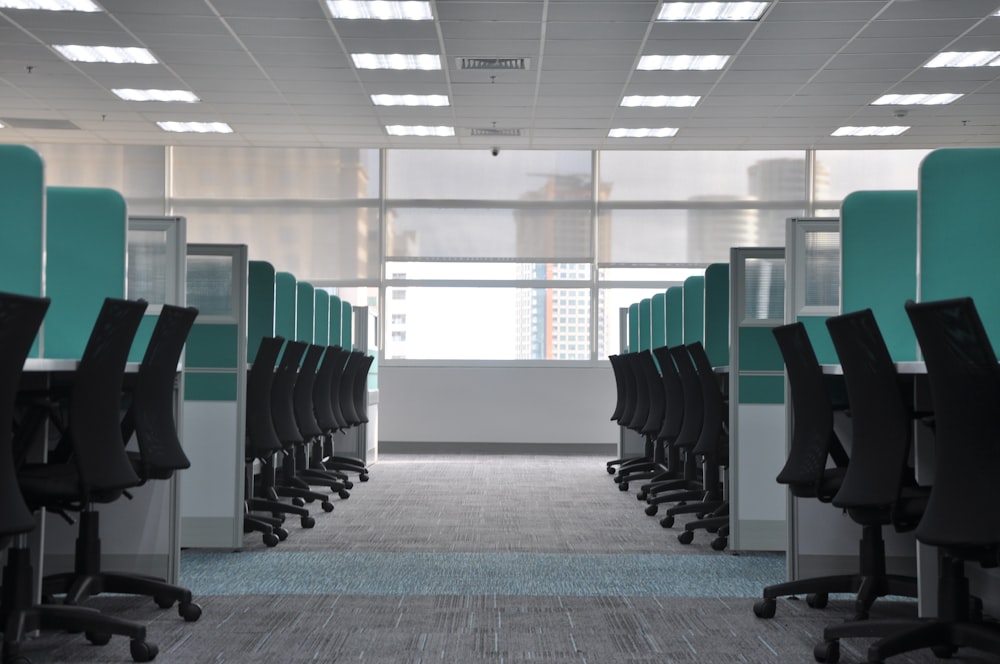 empty black rolling chairs at cubicles