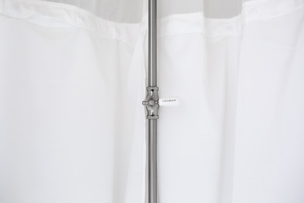 gray metal pole beside white curtain