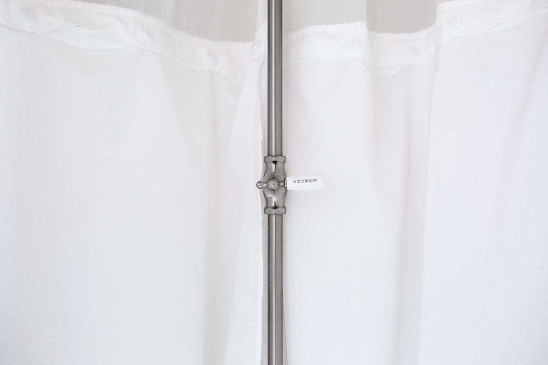 gray metal pole beside white curtain