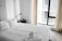 A bright, neatly made bed with crisp white linens in a boutique-style Airbnb room.