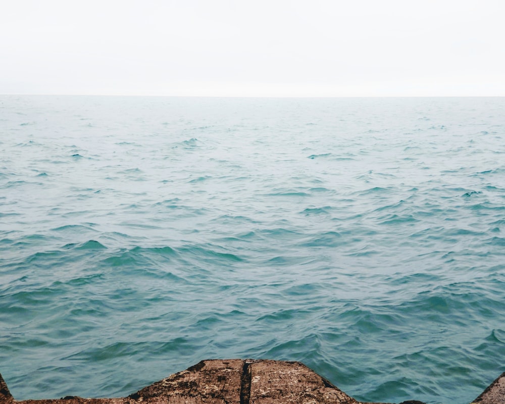 brown rock formation near body of water