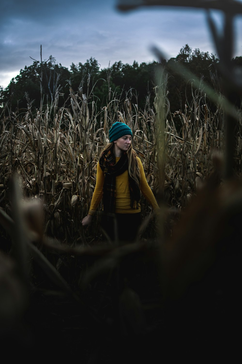 Fotografia a fuoco selettiva di una donna in piedi sul campo d'erba