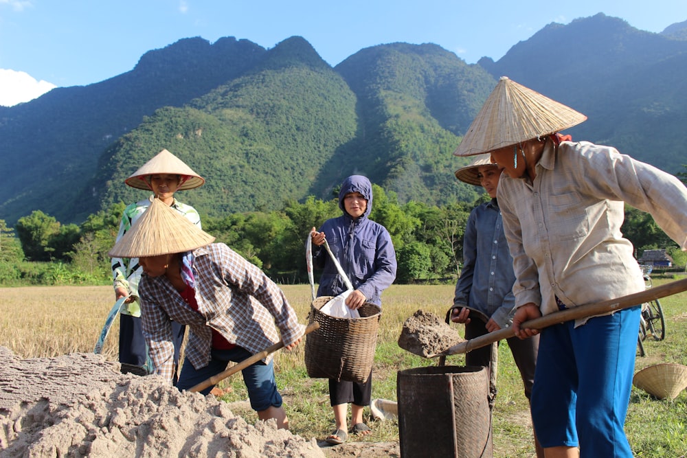 people digging soil near mountains during daytime