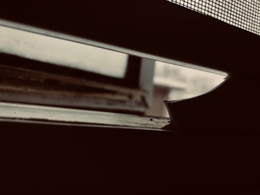 Close-up of a technician installing mosquito net velcro on a window frame in Chennai.