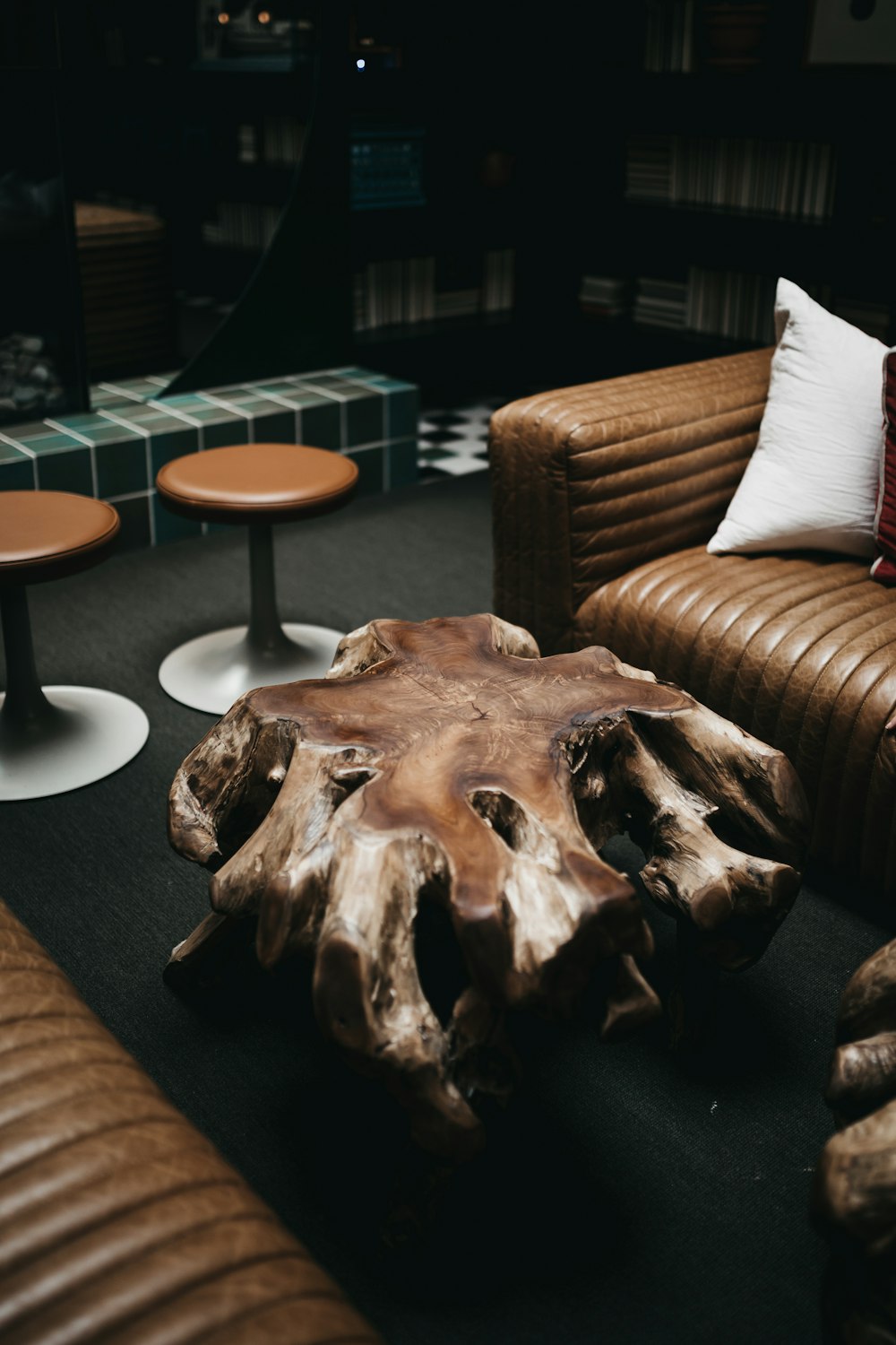 white throw pillow on brown sofa near decorative coffee table and vacant bar stools