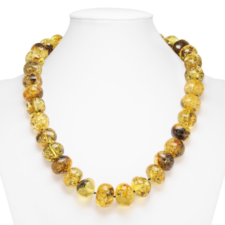 A necklace composed of large, round amber beads strung together, displayed on a white mannequin bust. The beads are polished and exhibit natural inclusions, giving them a unique and organic appearance with shades of yellow and brown.