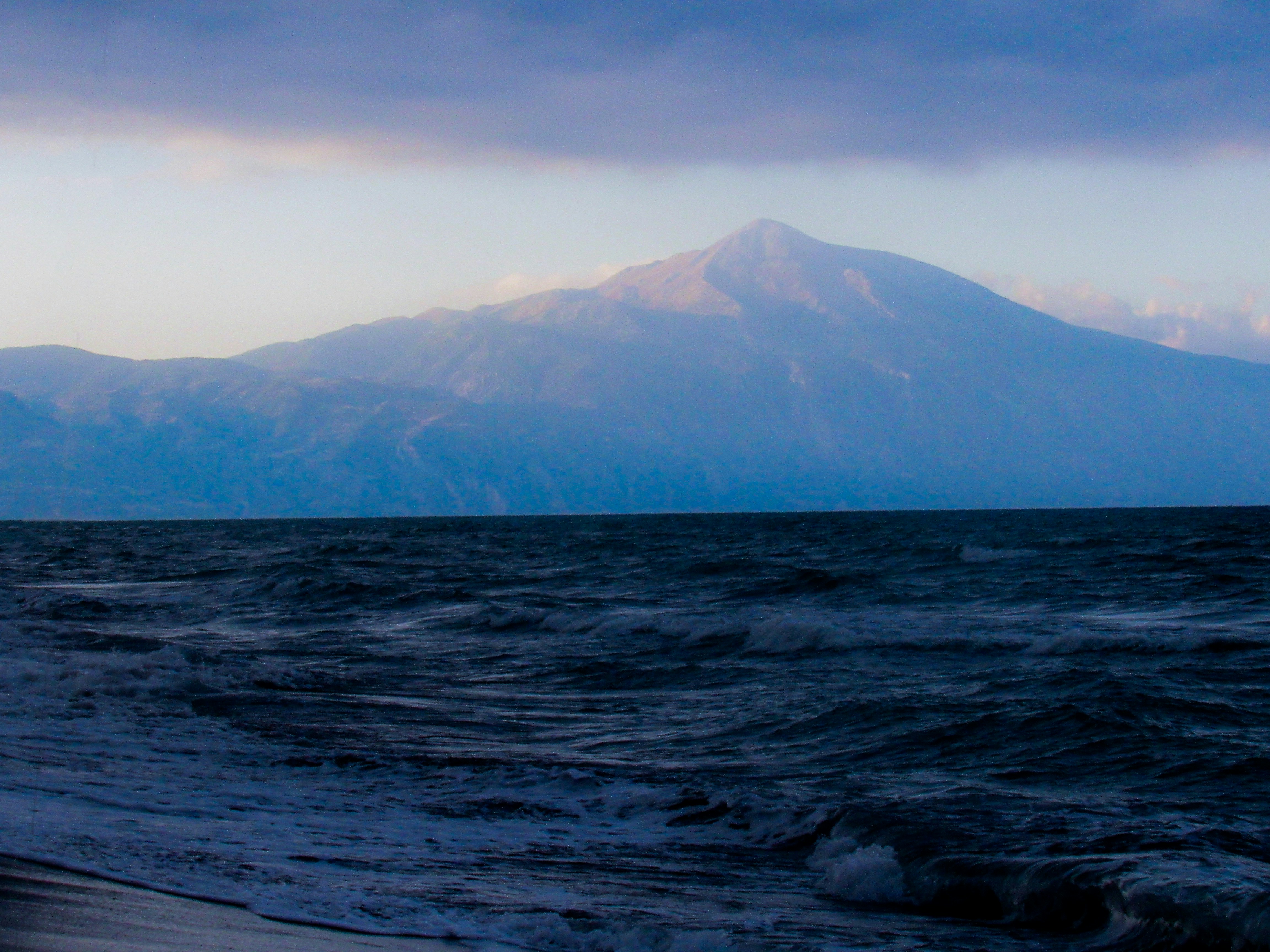 Pantai yang menghadap ke pegunungan di siang hari