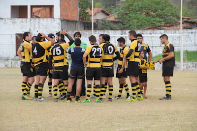 A coach mentoring a diverse group of enthusiastic youth during a rugby training session.