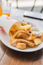 A vibrant plate of crispy fish fry served with a dipping sauce.