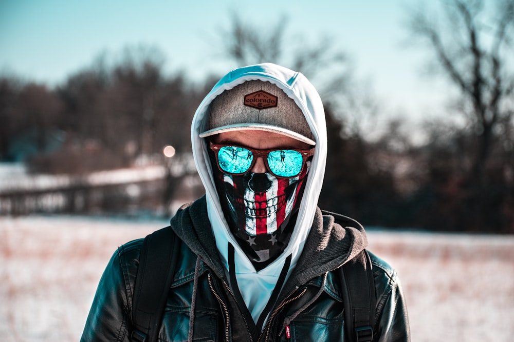 man wearing black leather jacket and white hoodie with brown hat photo