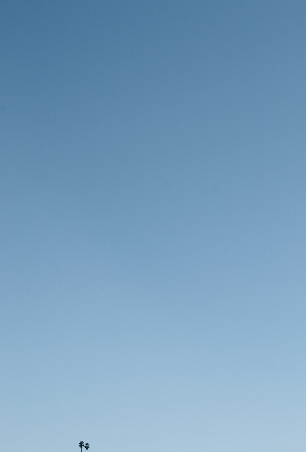 a person flying a kite in a blue sky