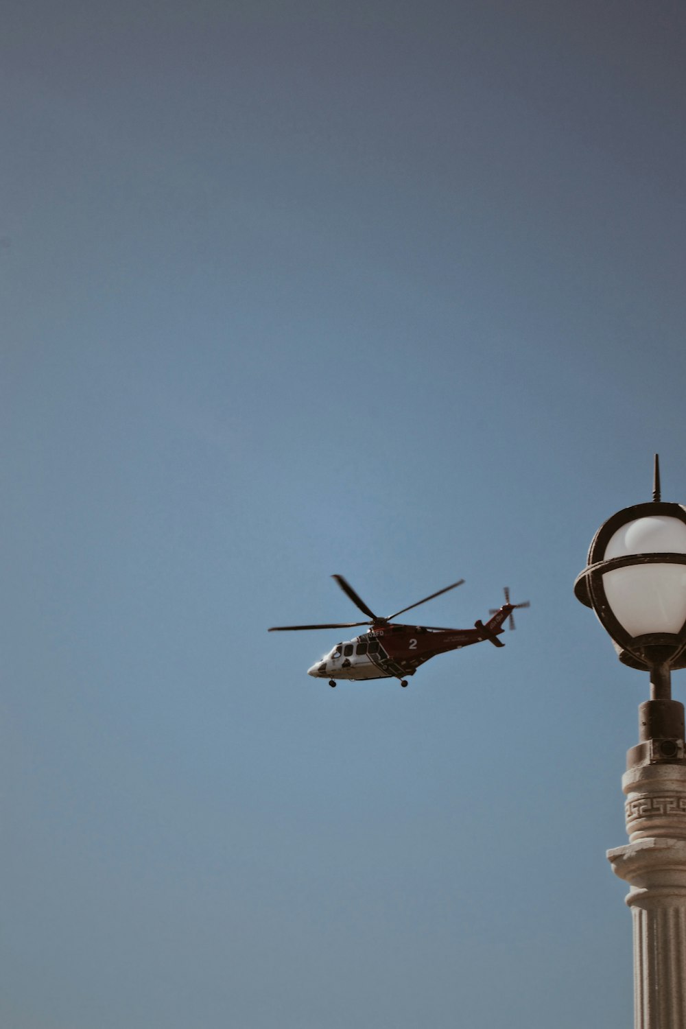 white and red helicopter flying during daytime