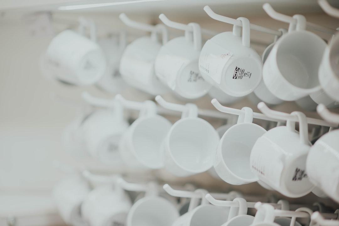 pile of white ceramic mugs in selective focus photography