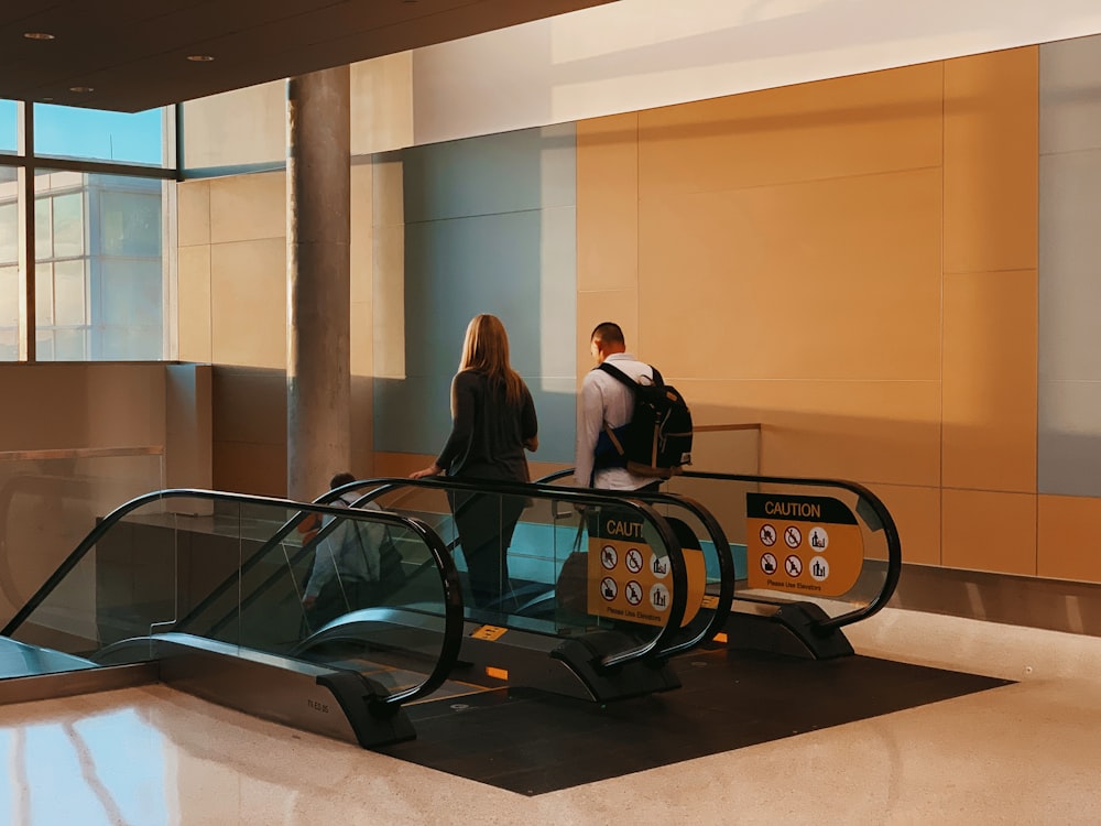 man and woman using escalator