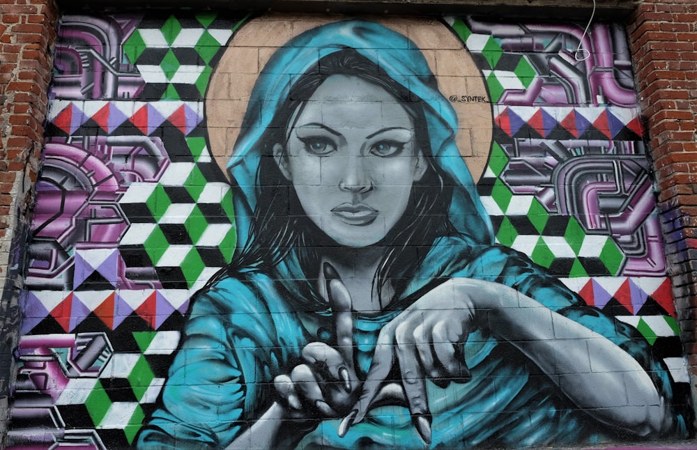woman wearing hooded top making LA hand sign graffiti
