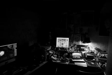 A sleek, dark-themed office with high-tech surveillance equipment and confidential files.