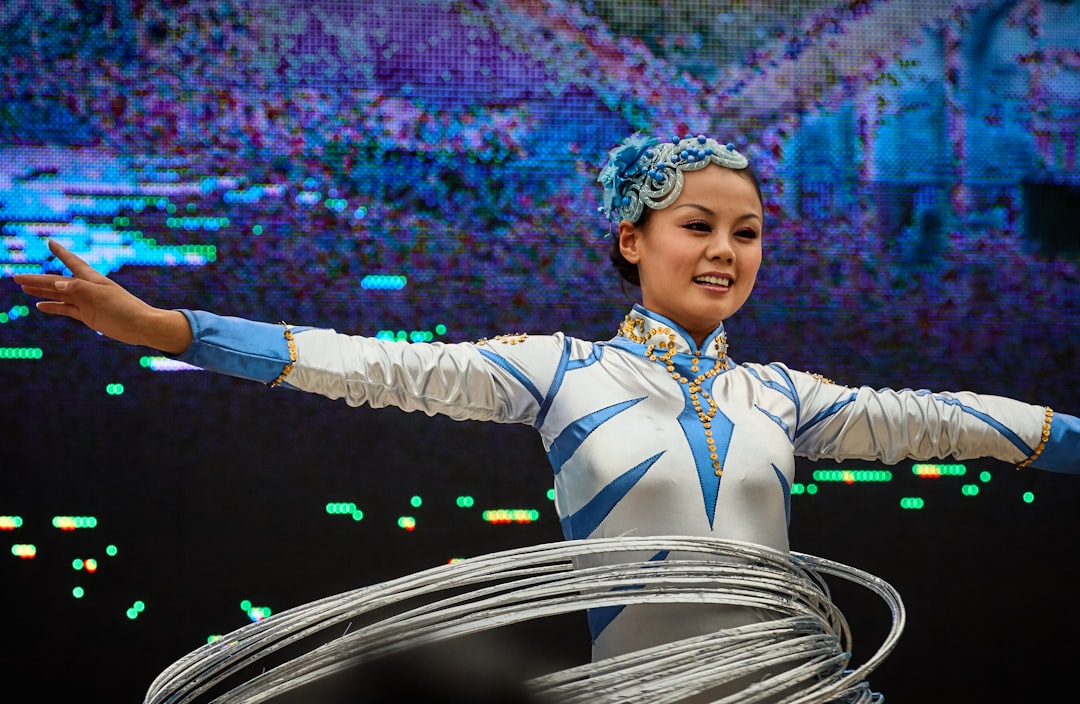 woman wearing white and blue long-sleeved dress doing hula hoops