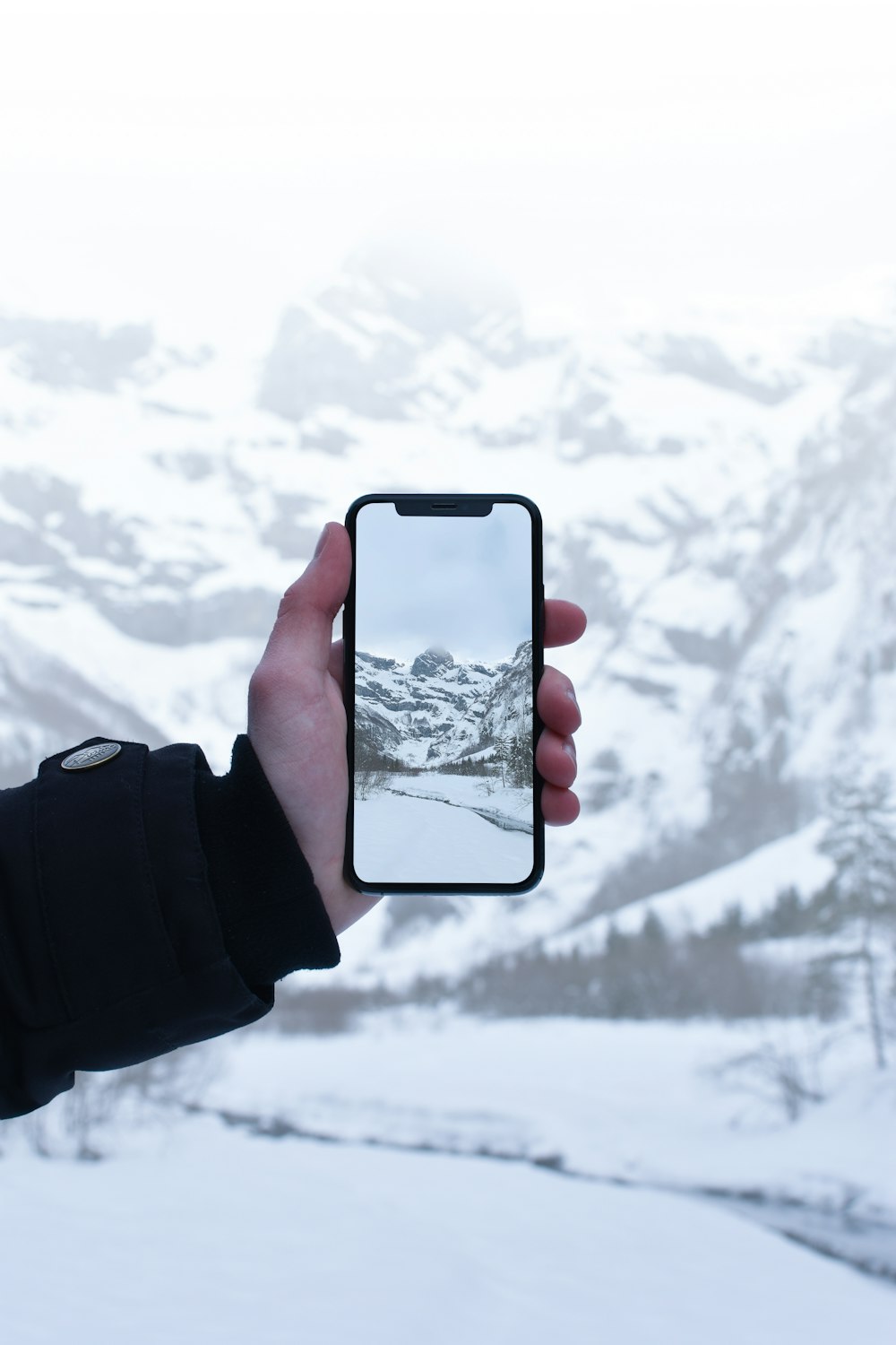 persona que toma una foto en la montaña cubierta de nieve