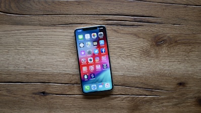 A person using a smartphone with a colorful app open on the screen.