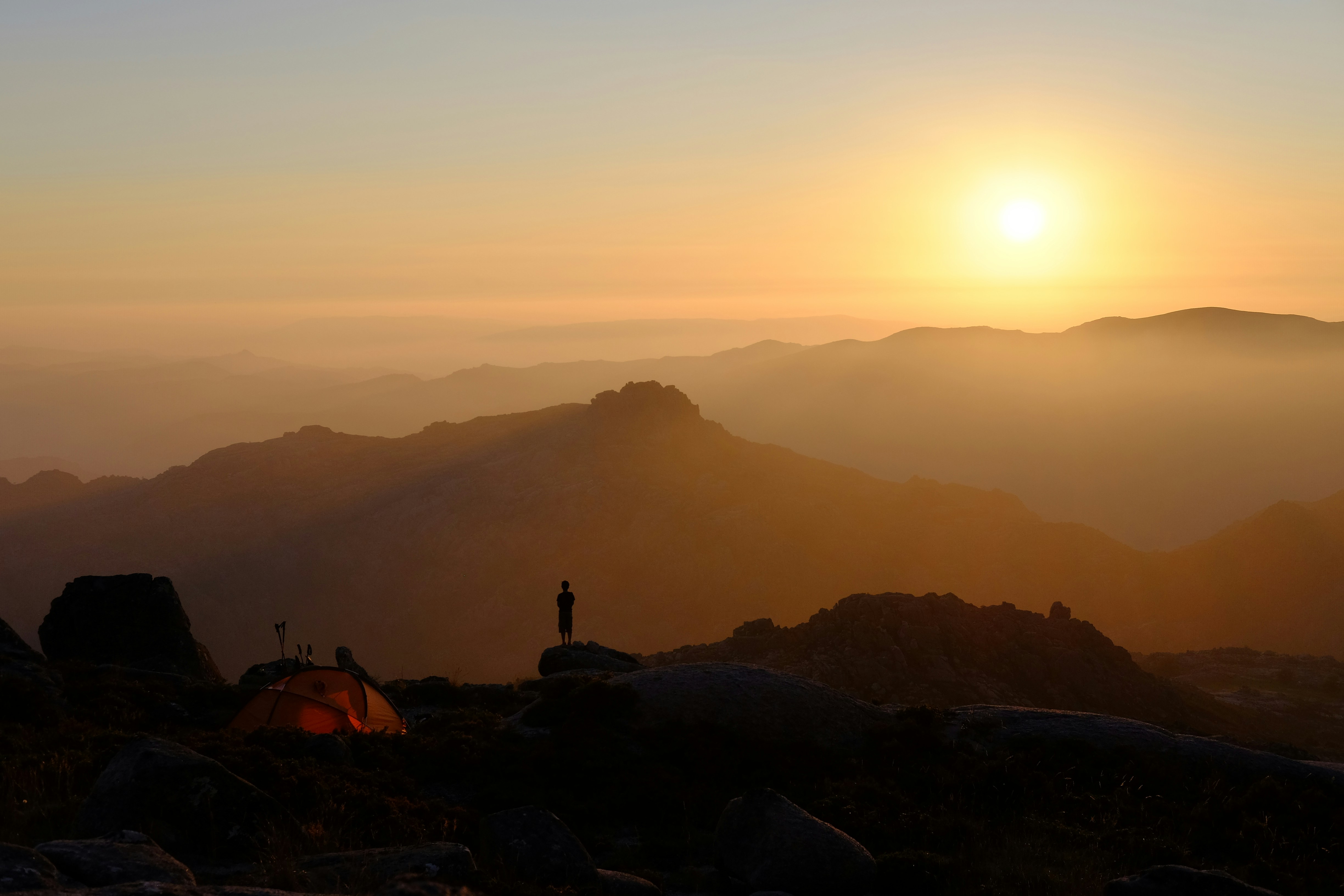 person standing on mountain near orange dome tent during sunrise, Once upon a time in Gerês