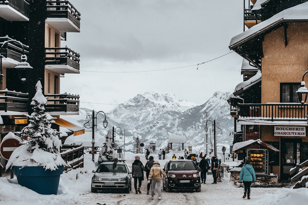 people standing near parked vehicle and building during daytime