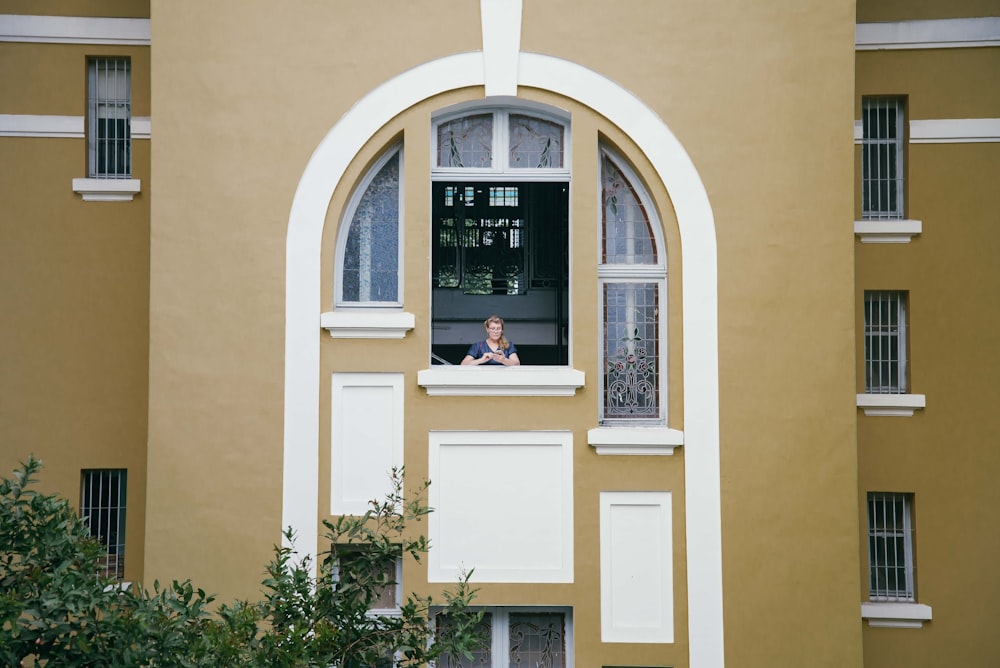 woman standing on window during daytime