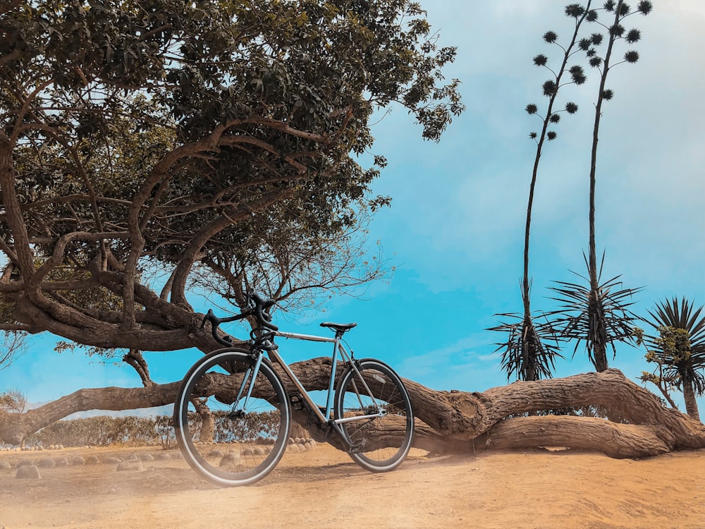 black road bike beside wood log