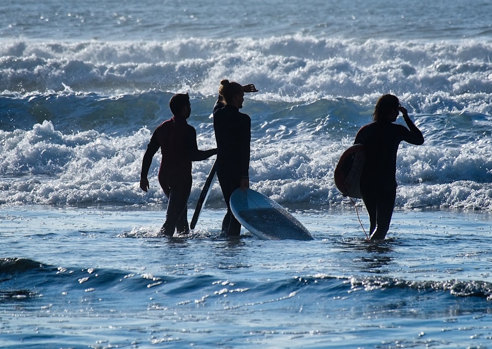 three people going to surf