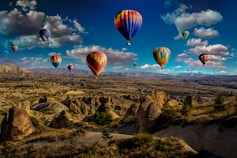 assorted-color hot air balloons over brown mountain range during daytime