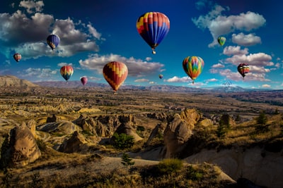 assorted-color hot air balloons over brown mountain range during daytime hot air balloon google meet background