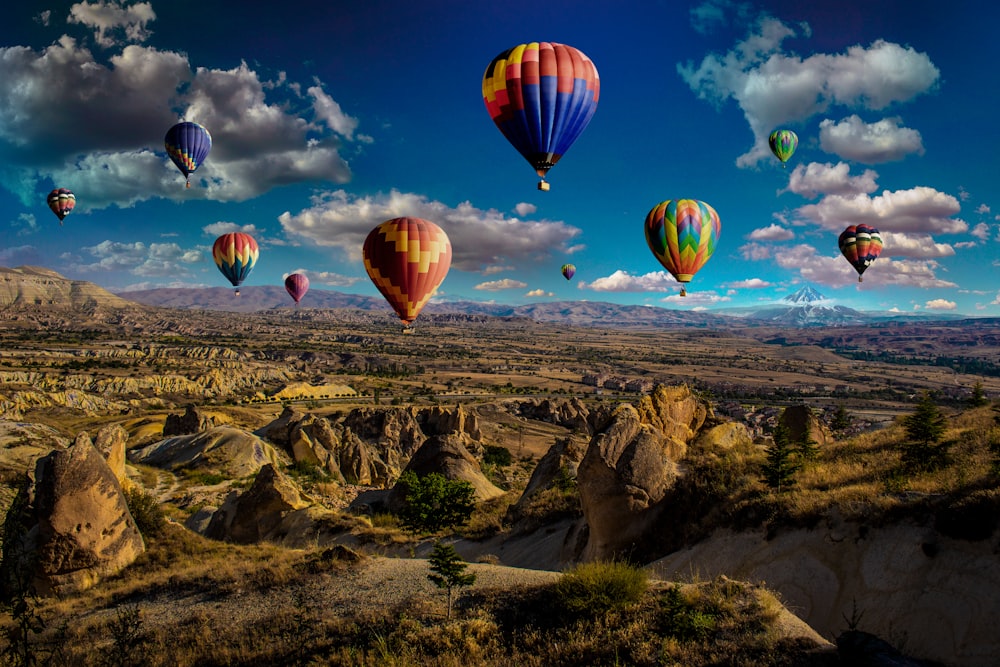 assorted-color hot air balloons over brown mountain range during daytime