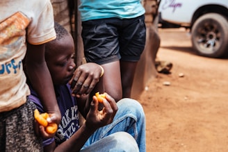 boy sitting while holding food during daytime