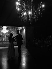 A romantic setting with a couple dancing under soft lighting.