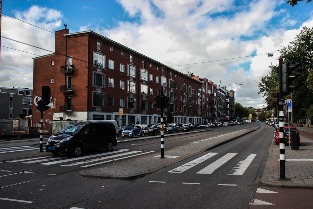 vehicles on road beside concrete buildings