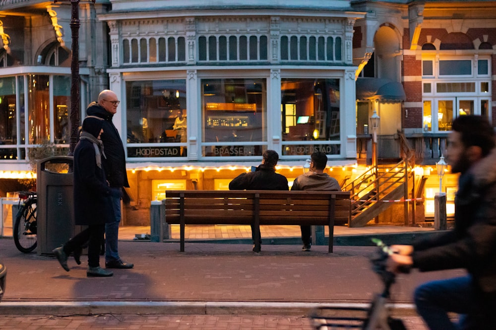 two men sitting on brown bench