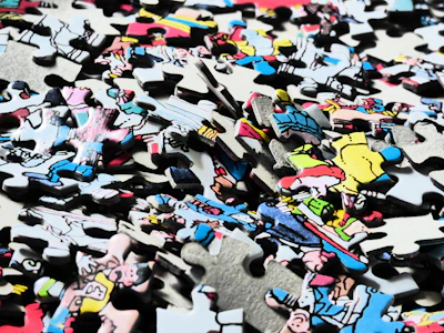 A colorful anime puzzle featuring detailed characters and dynamic scenes spread out on a table.