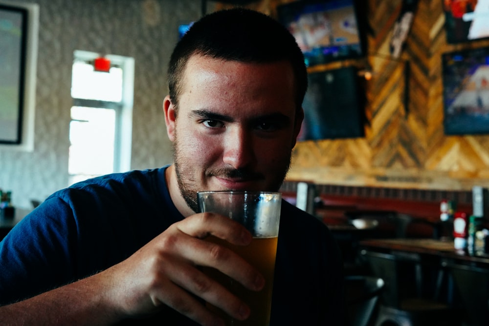 man holding clear glass cup