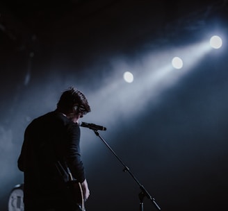 man standing beside black dynamic microphone