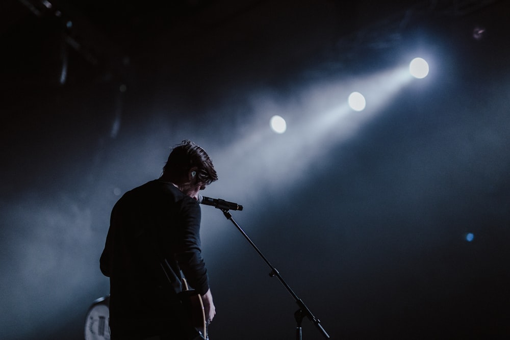 man standing beside black dynamic microphone