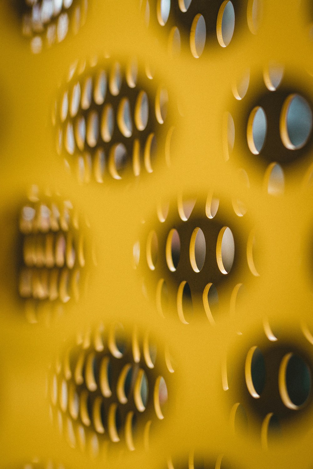 a close up of a yellow wall with holes in it