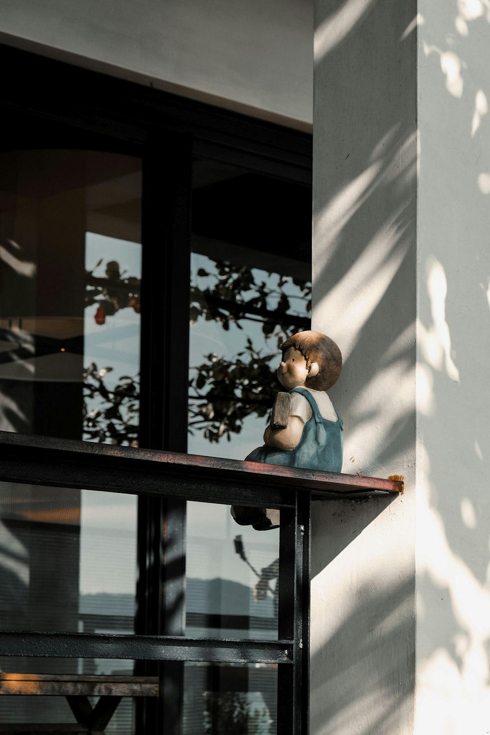 sitting child statuette on railing