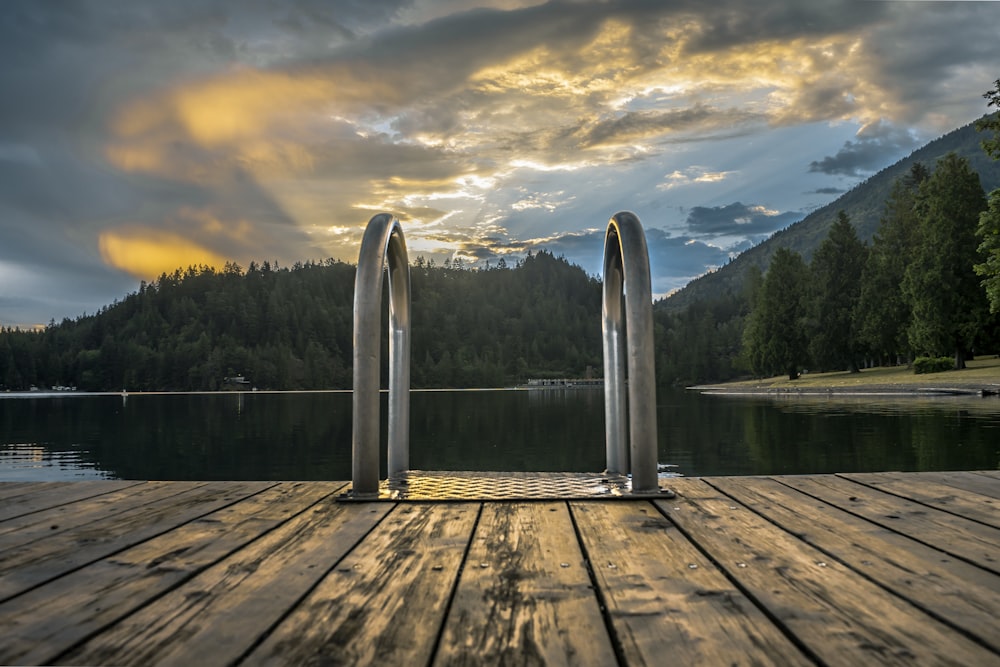 body of water beside brown wooden dock