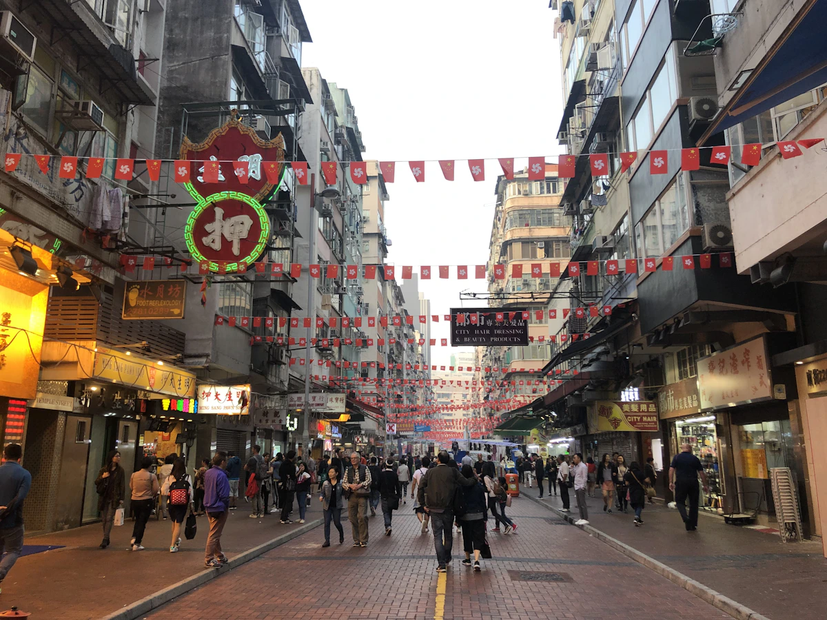 People walking beneath market awnings on Temple Street in Kowloon